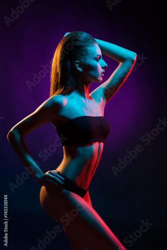 Young, beautiful and seductive girl posing in swimsuit. Mixed and fashionable lightning effect. © Acronym