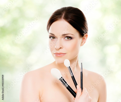 Close-up portrait of a beautiful woman: over green background. Healthcare, spa, makeup and face lifting concept.