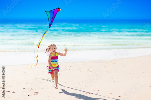 Child flying kite on tropical beach