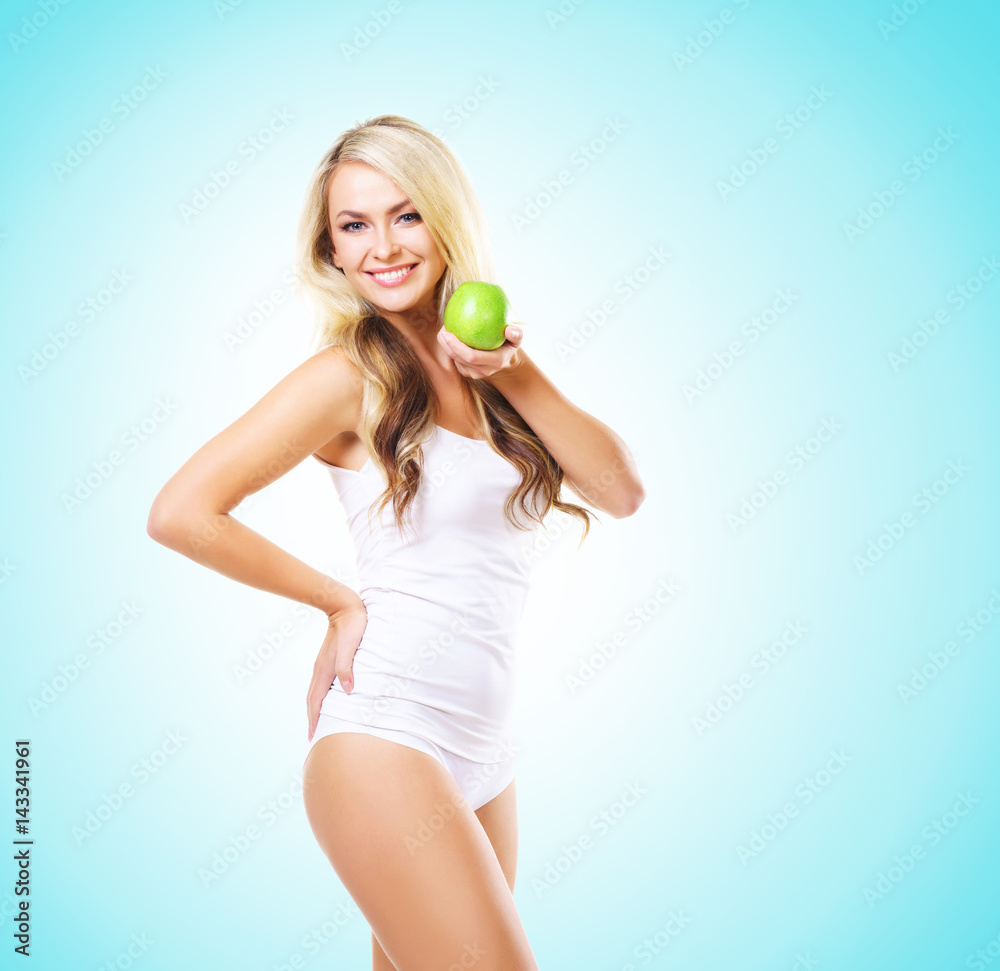 Fit and sporty girl in white underwear. Beautiful and healthy woman eating green apple over cyan background. Sport, fitness, diet, weight loss, nutrition and healthcare concept. Fit and sporty girl in white underwear. Beautiful and healthy woman eating green apple over cyan background. Sport, fitness, diet, weight loss, nutrition and healthcare concept.