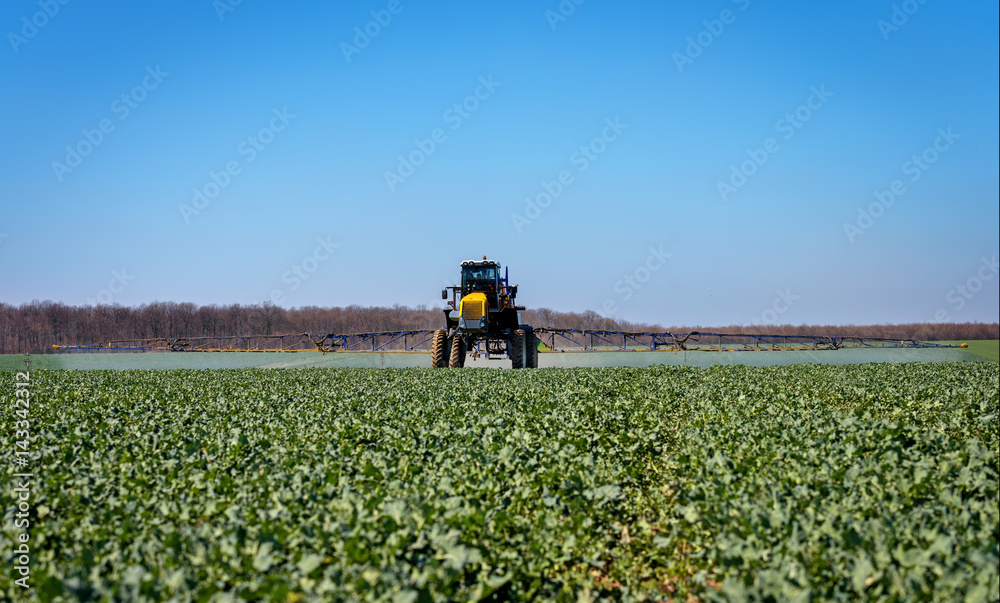 Farm machinery spraying insecticide to the green field. Farm machinery spraying insecticide to the green field.