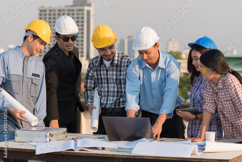 Group of engineers and architects discuss at a construction site