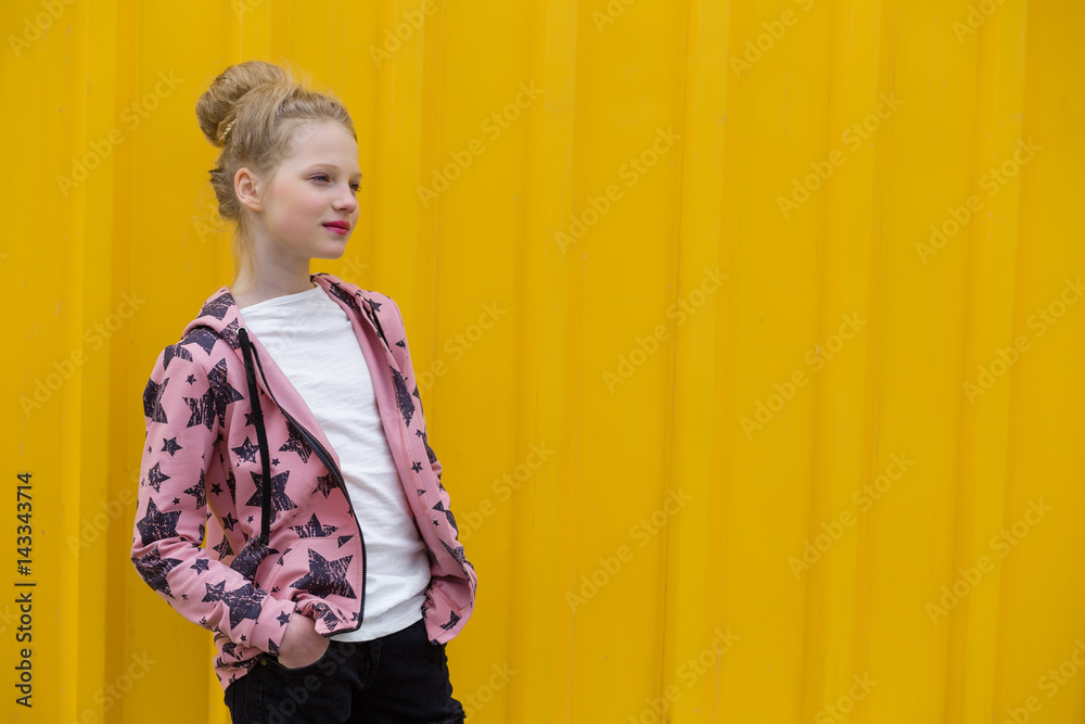 Portrait of a beautiful girl with red lips on a yellow background outdoors in summer