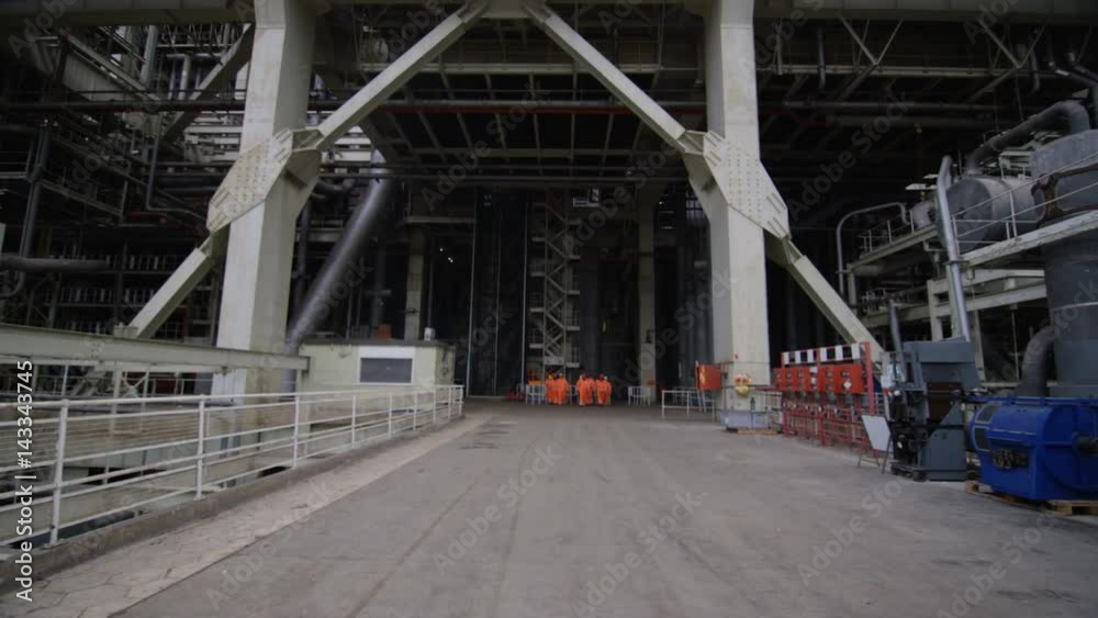 Team of engineers in power station, wide shot of workers & building structure Team of engineers in power station, wide shot of workers & building structure