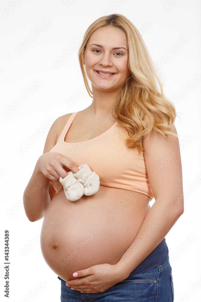 Best parent in the world. Vertical studio portrait of a young beautiful pregnant woman holding baby booties isolated on white. Best parent in the world. Vertical studio portrait of a young beautiful pregnant woman holding baby booties isolated on white.