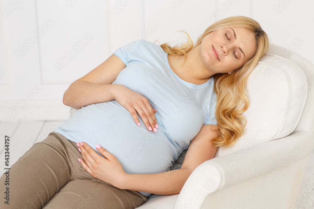 Perfect way to rest. Horizontal portrait of a beautiful pregnant woman sleeping peacefully on the sofa. Perfect way to rest. Horizontal portrait of a beautiful pregnant woman sleeping peacefully on the sofa.