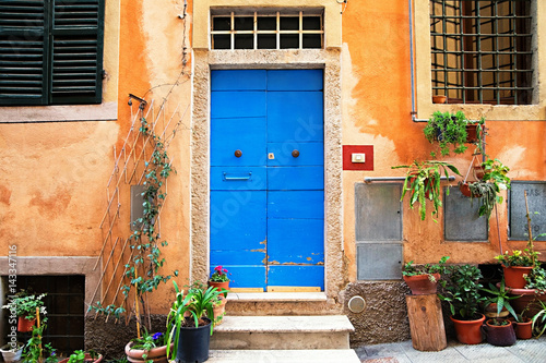 classic italian house with blue door and  orange walls