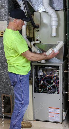 HVAC Technician Installing Furnace Using PVC Piping