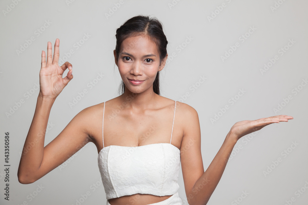 Beautiful young Asian woman show palm hand and OK sign. Beautiful young Asian woman show palm hand and OK sign.