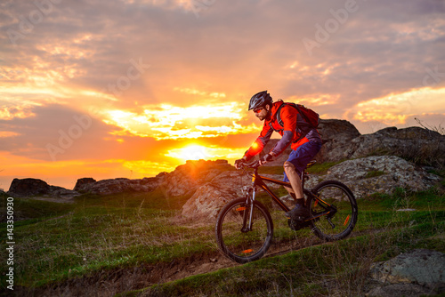 Cyclist Riding Mountain Bike on the Spring Rocky Trail at Beautiful Sunset. Extreme Sports and Adventure Concept. © Maksym Protsenko