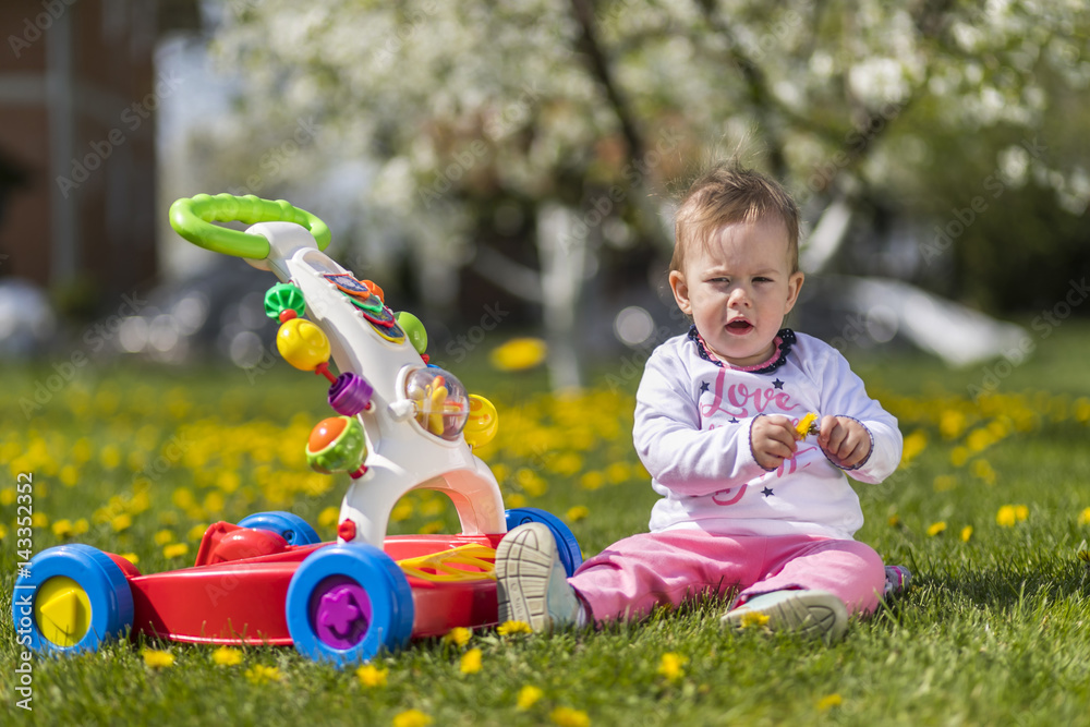 Happy little baby girl on the meadow with yellow flowers Happy little baby girl on the meadow with yellow flowers