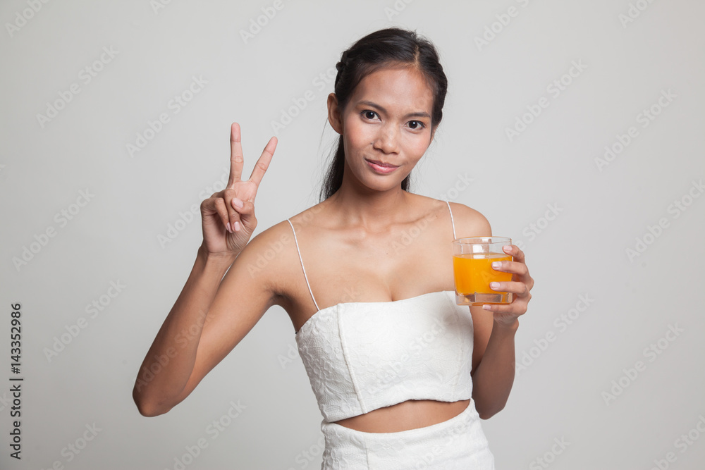 Young Asian woman show victory sign drink orange juice. Young Asian woman show victory sign drink orange juice.