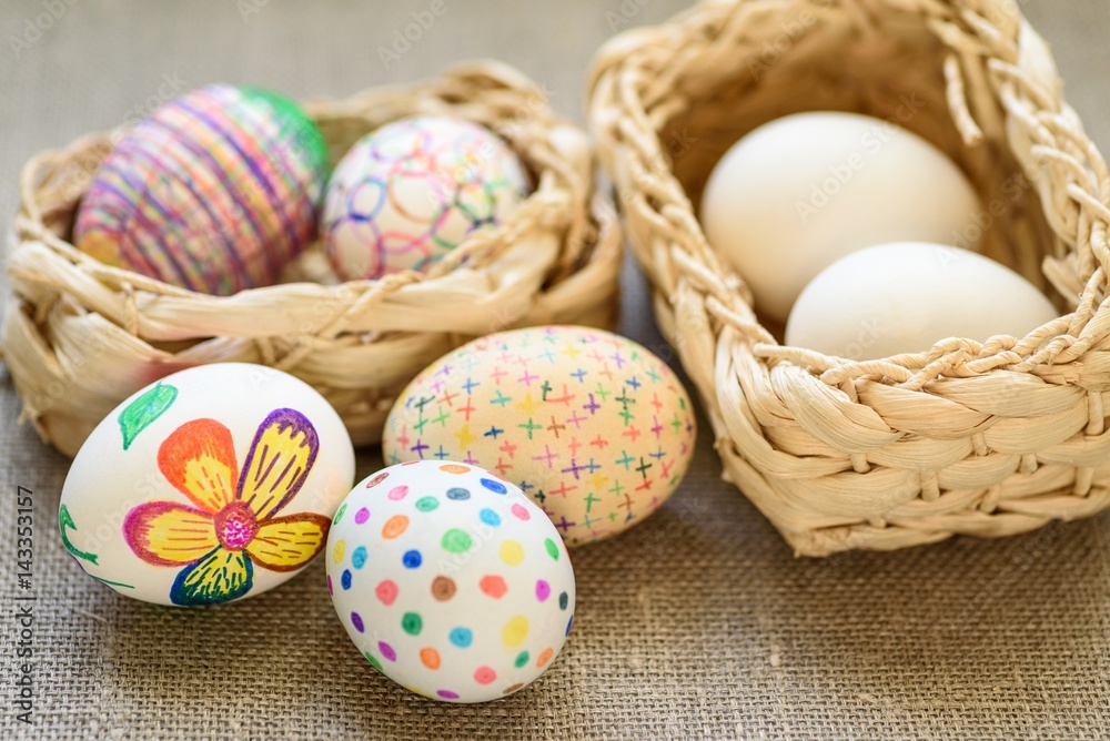 Easter eggs in a 2 wicker baskets on the tablecloth of burlap