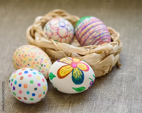 Easter eggs in a 1 wicker basket on the tablecloth of burlap