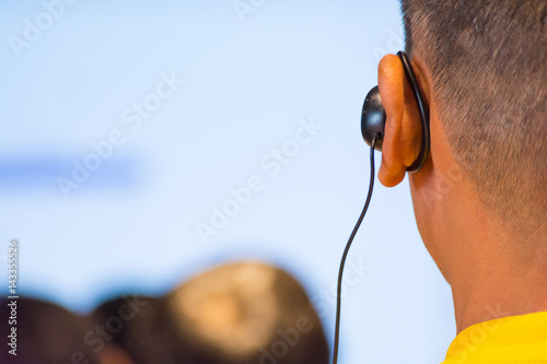 The Male Audience at International Business Meeting or Seminar wearing headphone for online Translation
