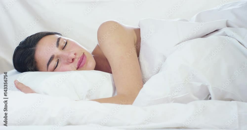 A simple day off for a beautiful young girl sleeping in a warm bed, covered with a soft warm white blanket, on a white background. A simple day off for a beautiful young girl sleeping in a warm bed, covered with a soft warm white blanket, on a white background.