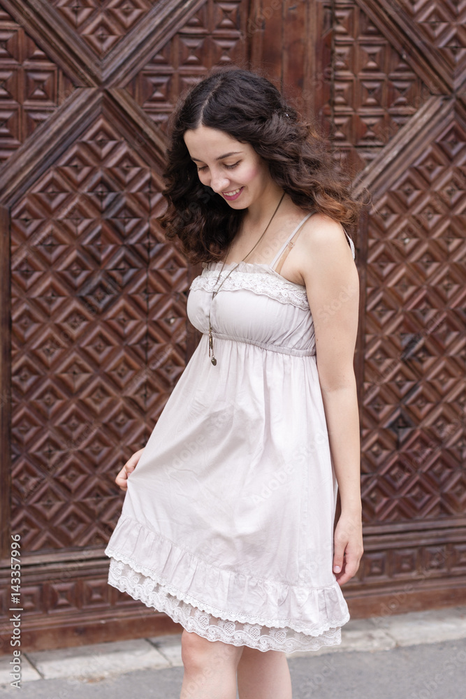 Naklejka premium Young girl in front of wooden vintage door