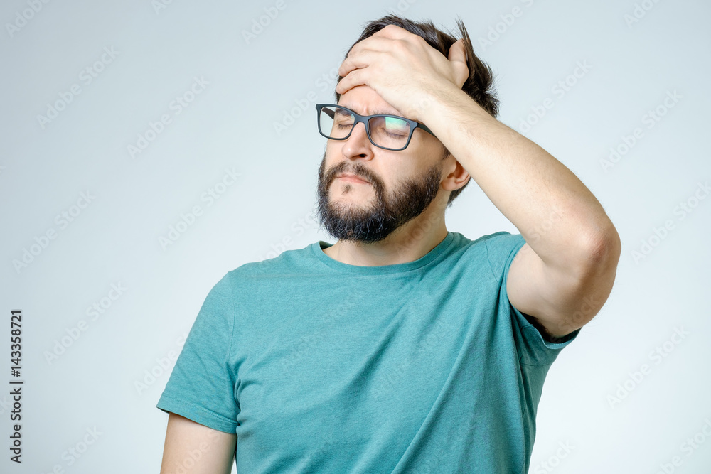 Depressed handsome bearded man touching having a headache Depressed handsome bearded man touching having a headache