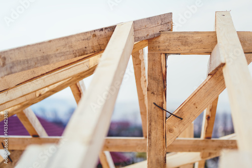 Details of construction site, timber structure of truss roof system. The wooden structure of the building © aboutmomentsimages