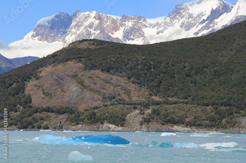 Snow capped mountain and blue iceberg in a lake. El Calafate, Patagonia, Argentina