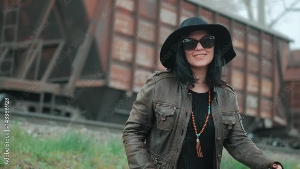 Portrait of young laughing woman in black hat near train in motion Portrait of young laughing woman in black hat near train in motion