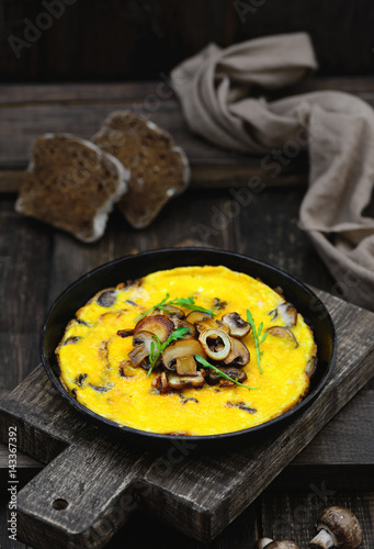 Omelette with mushrooms in a frying pan