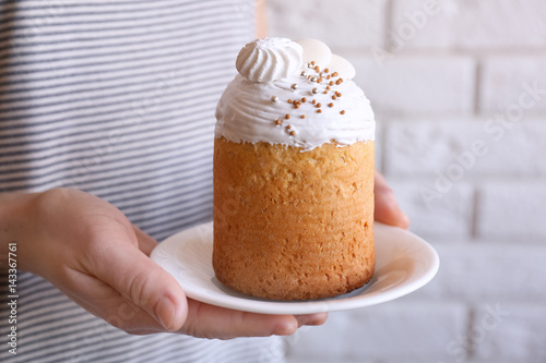 Woman holding plate with traditional Russian Easter cake photo