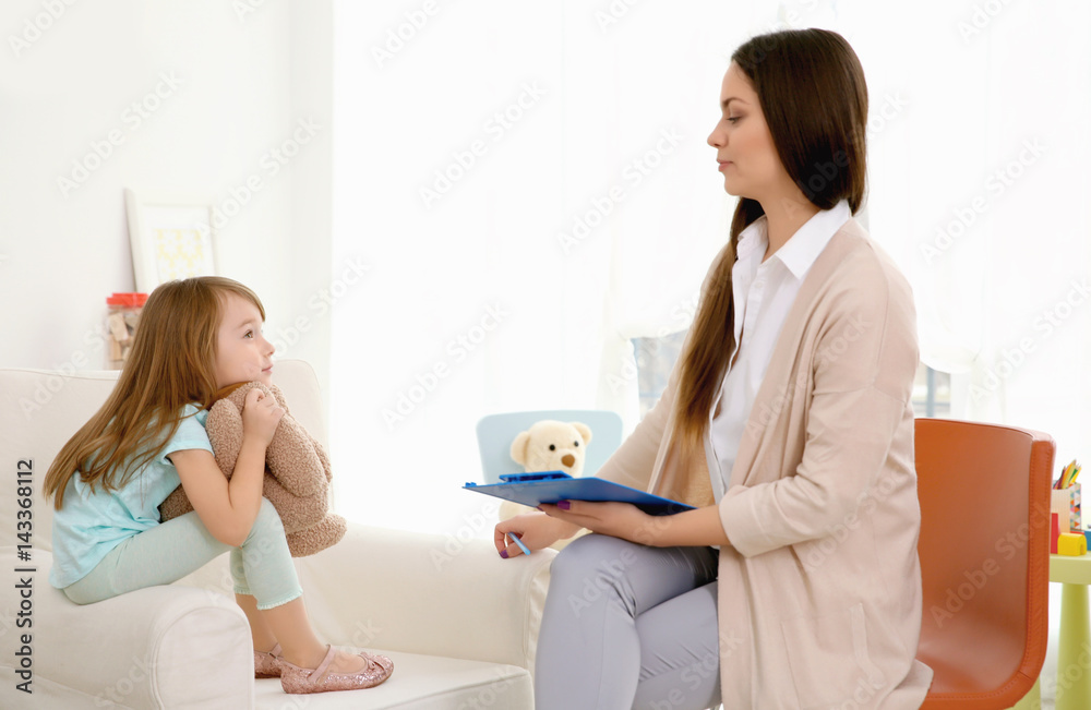 Young child psychologist working with little girl