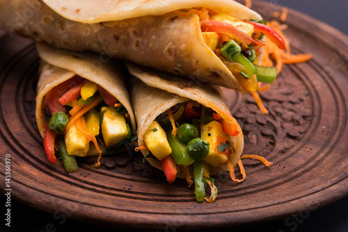 Indian popular snack food called Vegetable spring rolls or veg roll or veg franky made using paneer or cottage cheese and vegetables wrapped inside paratha/chapati/roti with tomato ketchup.