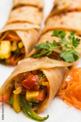 Indian popular snack food called Vegetable spring rolls or veg roll or veg franky made using paneer or cottage cheese and vegetables wrapped inside paratha/chapati/roti with tomato ketchup.