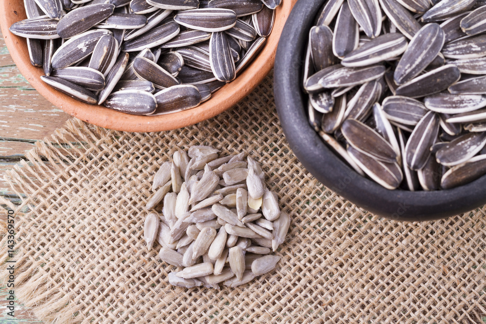 pile of sunflower seeds on wooden background