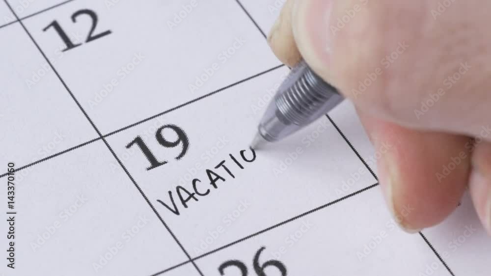 Writing VACATION on a calendar to remember this date.
