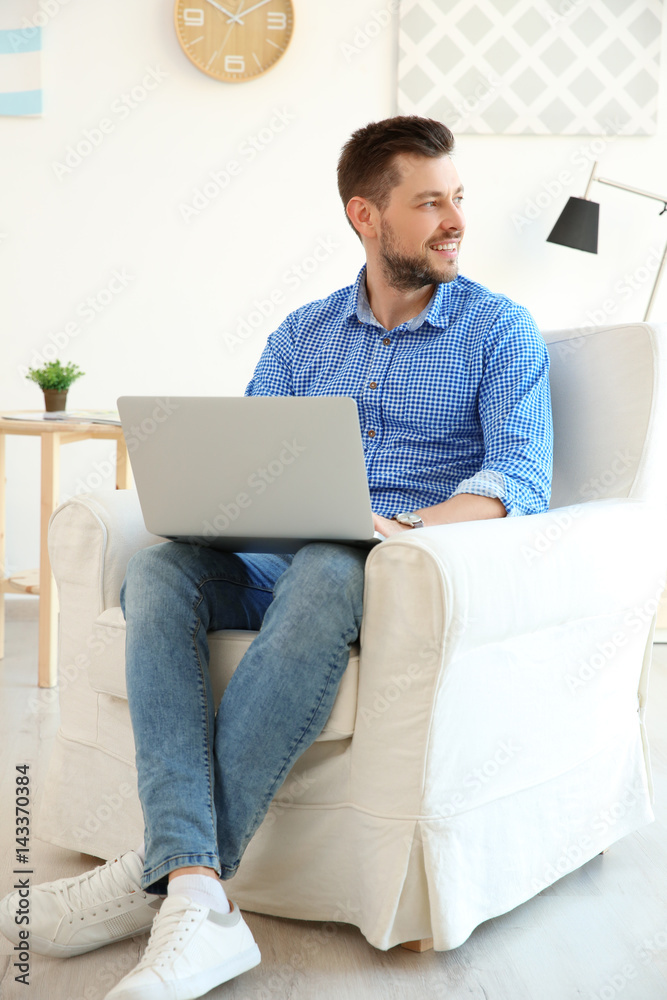 Handsome young man with laptop at home Handsome young man with laptop at home