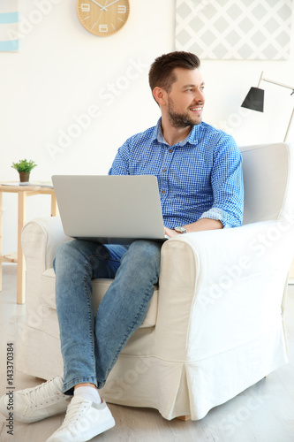 Handsome young man with lap...