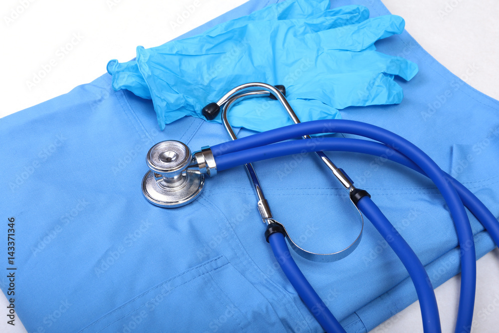 Medical stethoscope, Gloves, RX prescription on blue doctor uniform closeup. Medical tools and instruments shop, blood pressure measurement concept Medical stethoscope, Gloves, RX prescription on blue doctor uniform closeup. Medical tools and instruments shop, blood pressure measurement concept