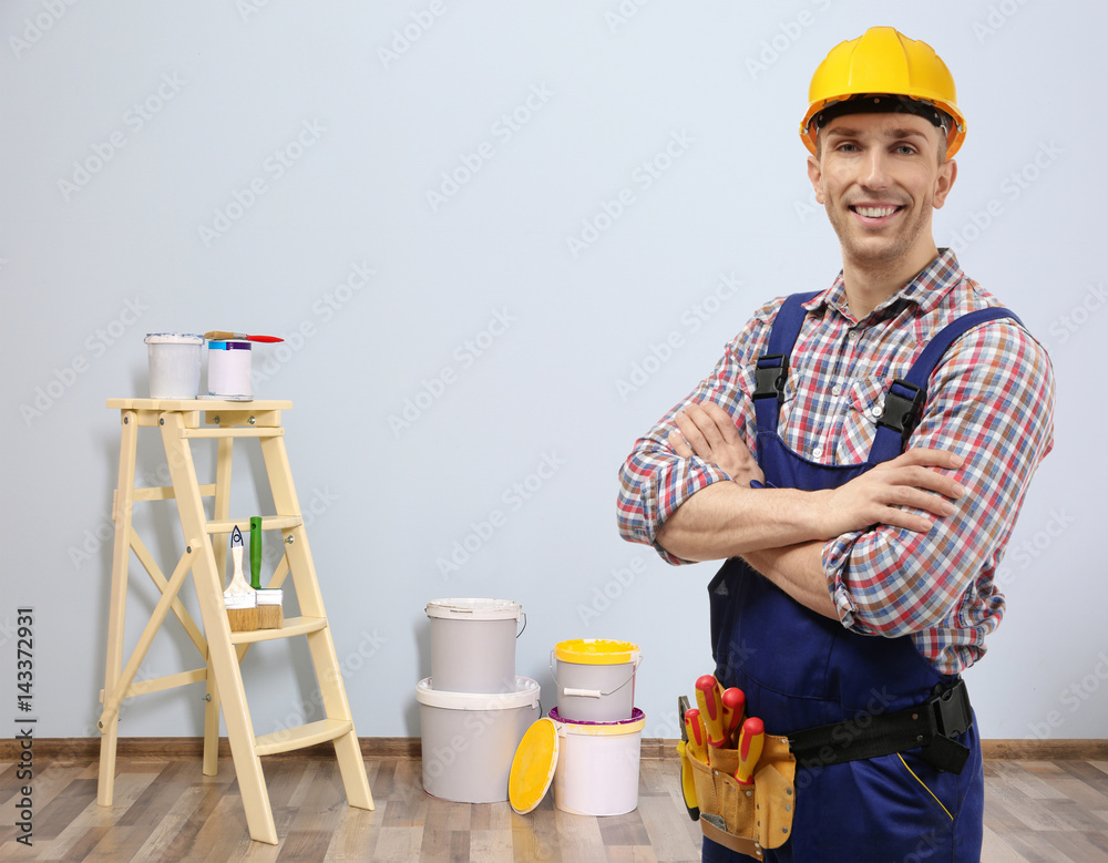 Young electrician with tools on white background