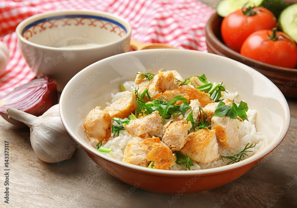 Delicious rice with chicken in bowl on table Delicious rice with chicken in bowl on table