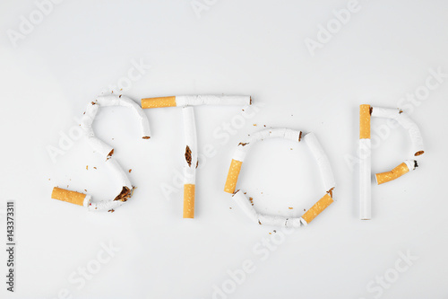 Word STOP made of cigarettes on white background