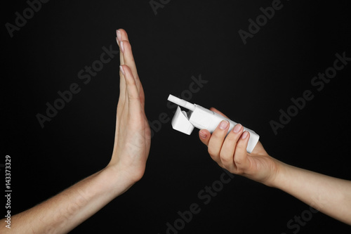 No smoking concept. Woman refusing of offered cigarette on black background