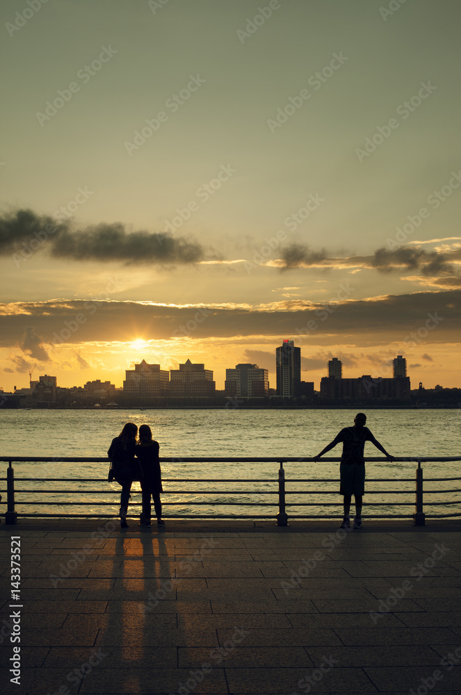 USA, New York, New York City, People looking at Manhattan skyline at sunset USA, New York, New York City, People looking at Manhattan skyline at sunset