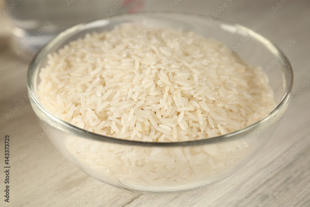 Glass bowl with rice on wooden table Glass bowl with rice on wooden table