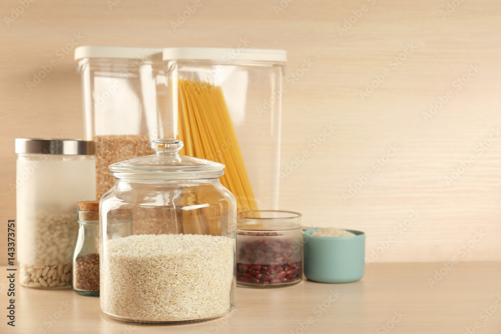 Kitchen containers with groceries on wooden table Kitchen containers with groceries on wooden table