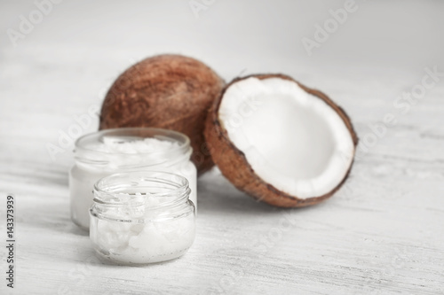 Fresh coconut oil and nuts on wooden background