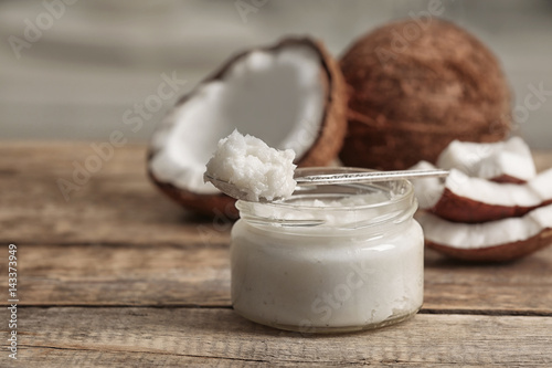 Fotografie Fresh coconut oil in glass jar and spoon on wooden table