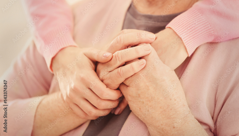 Young female hands hugging old woman, closeup Young female hands hugging old woman, closeup