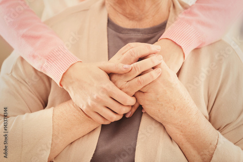 Young female hands hugging old woman, closeup