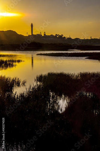 El Rompido lighthouse and marina at sunrise from marshlands photo