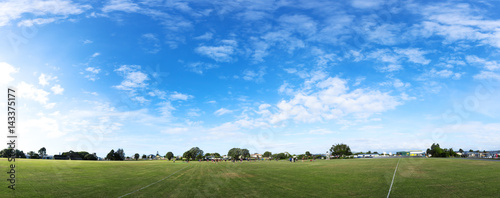 green rugby field in blue sky