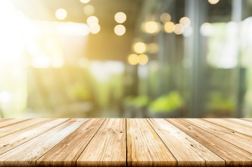 Empty light wood table top with blurred in coffee shop background