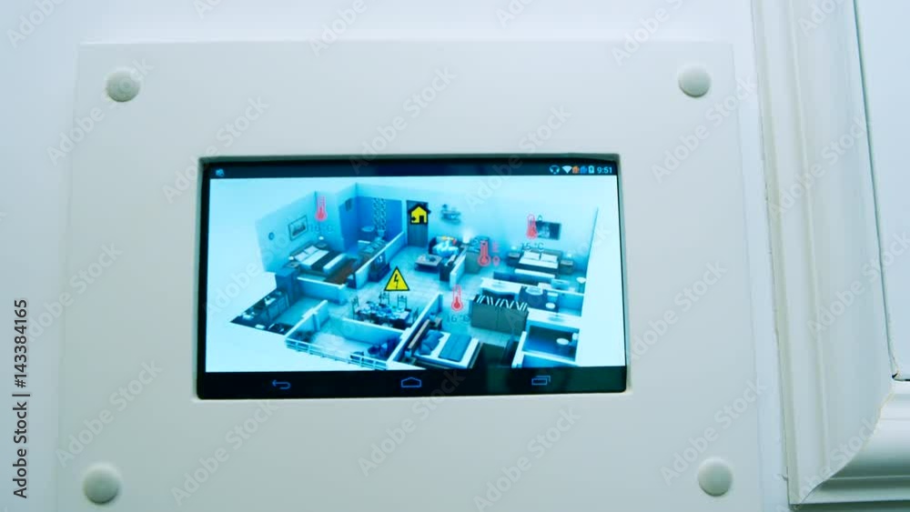 A man changing the temperature on a programmable thermostat on the house wall A man changing the temperature on a programmable thermostat on the house wall